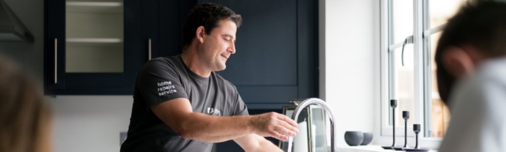 Man maintaining home by fixing tap