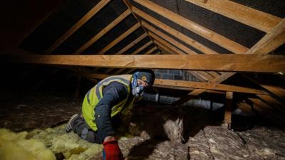 Man installing loft insulation