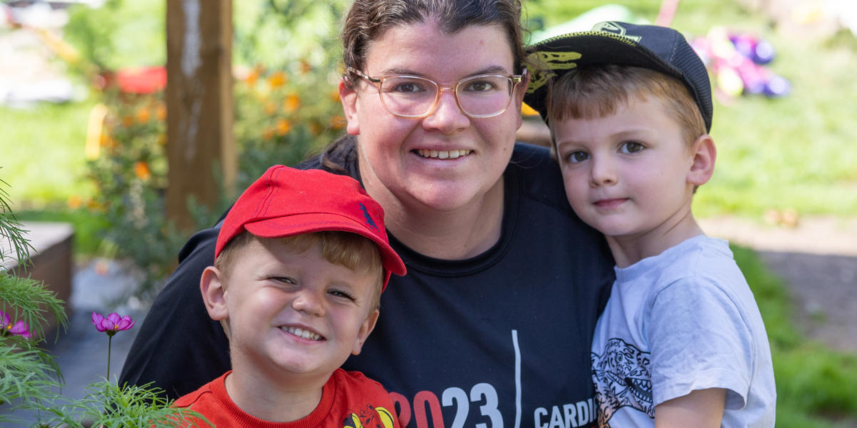 Mum hugging her two sons on allotment