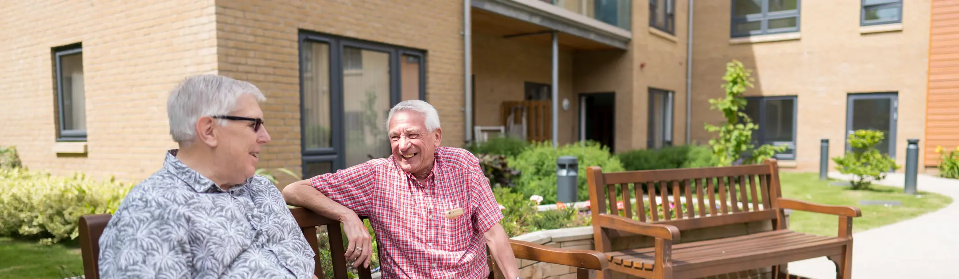 two men sat on bench outside their homes