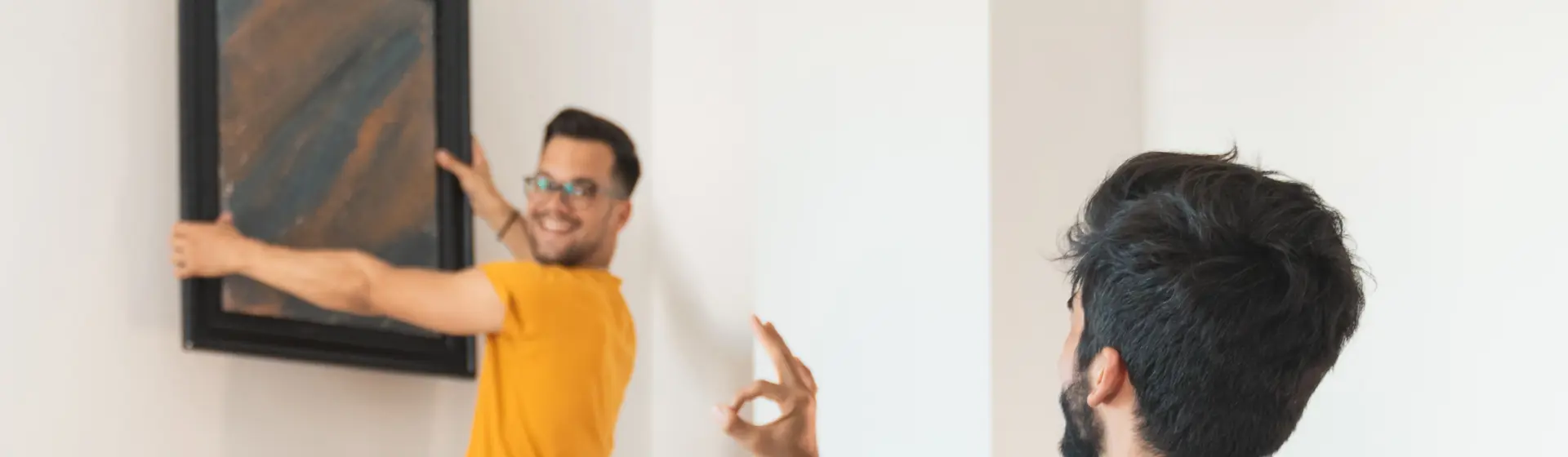 man hanging a picture