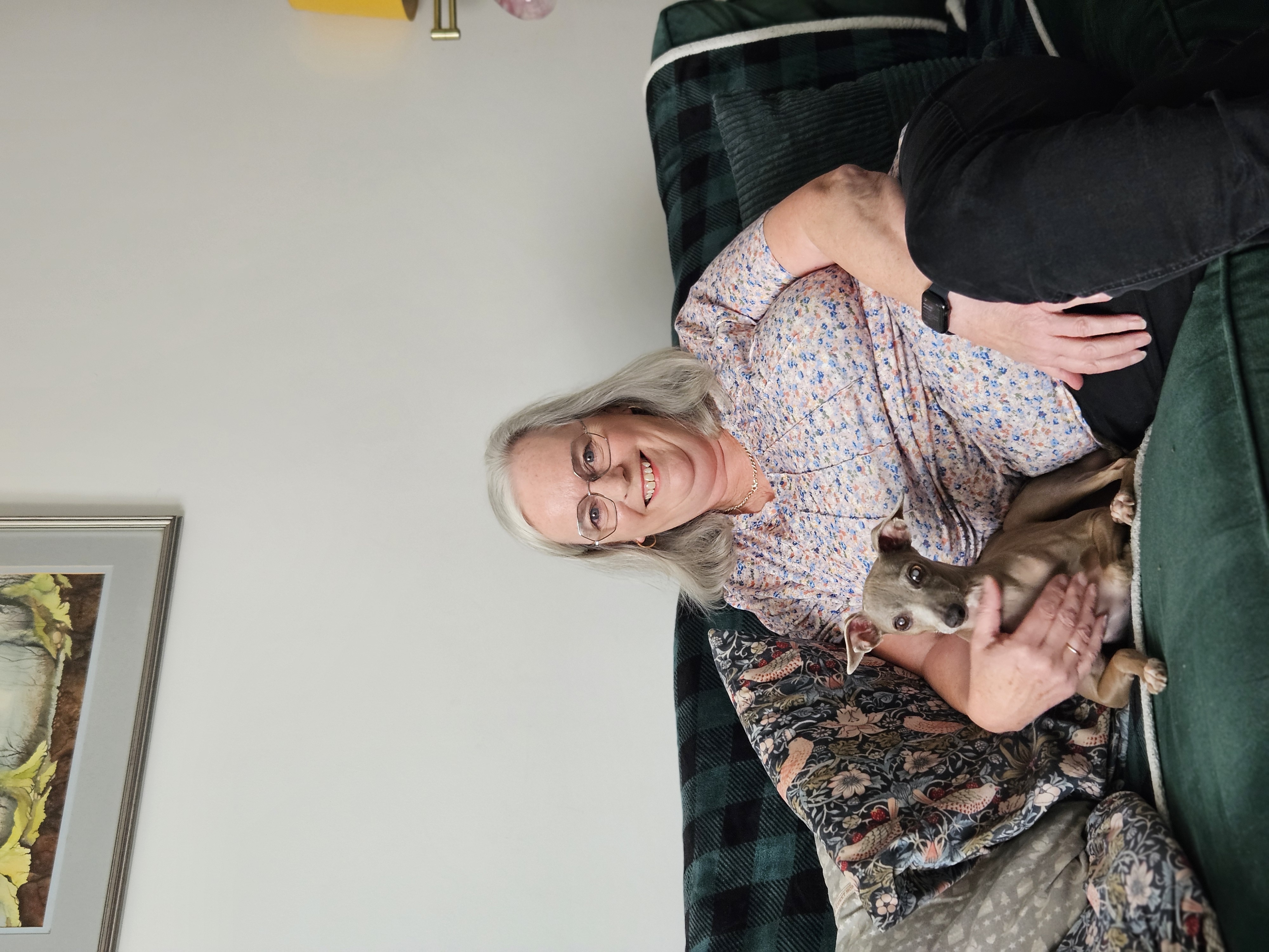 Women sitting on sofa with dog.