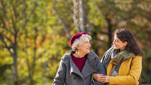 woman walking with senior woman in park