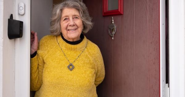 Elderly Woman Standing In Her Door Way