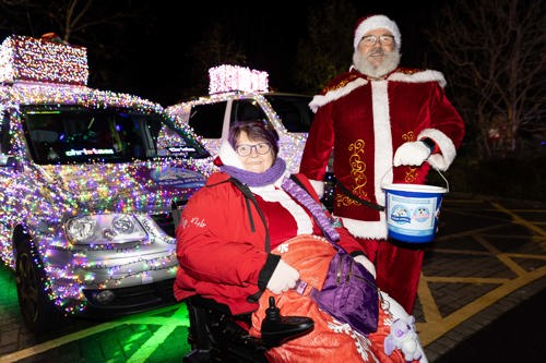 Santa Claus and Mrs Claus with a fundraising bucket.